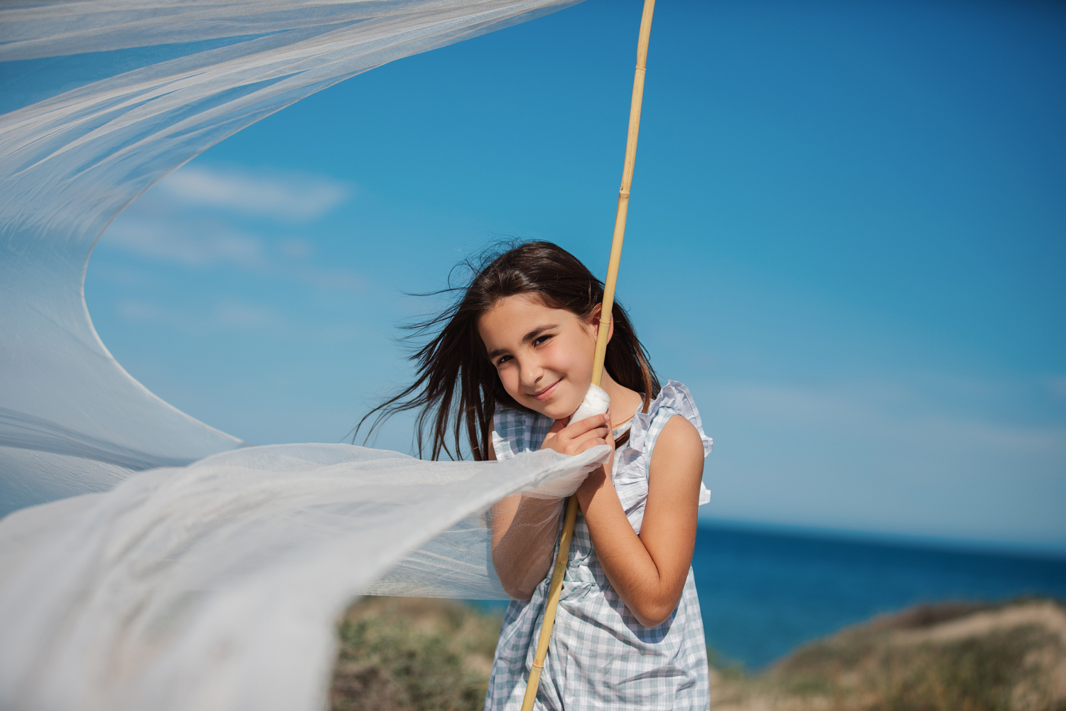 Niña con bandera en la playa